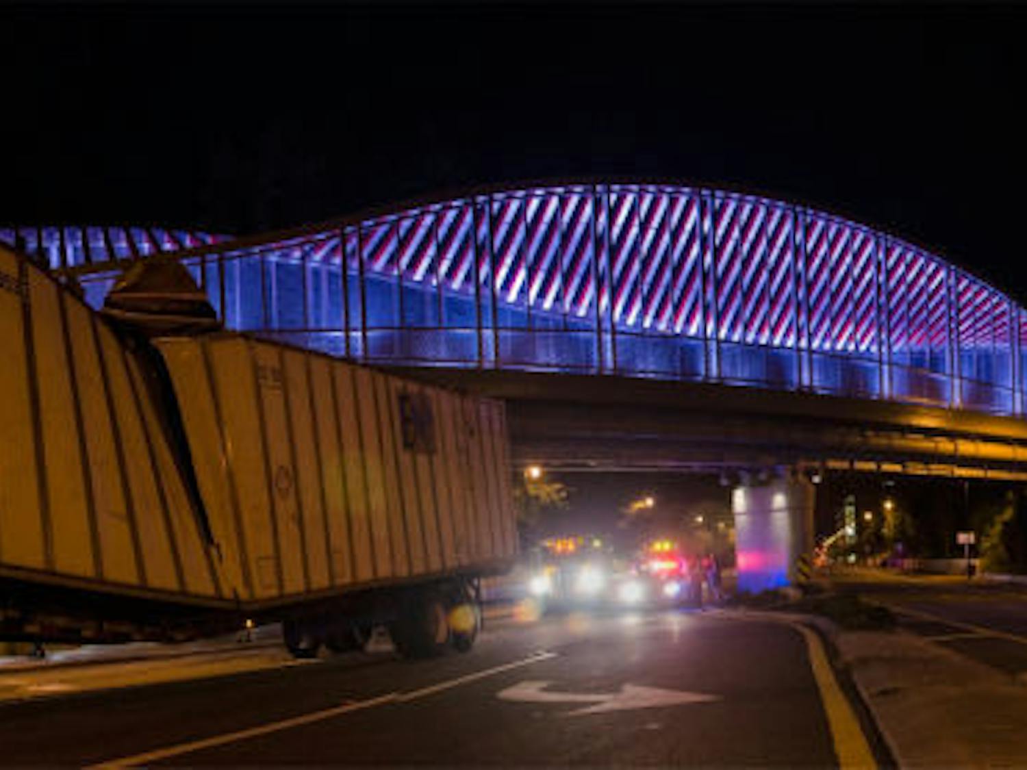 The northbound lanes of the 2100 block of Southwest 13th Street were closed Sunday night after the DNA bridge knocked a trailer off a tow truck near Archer Road, as seen in this stitched photo. The trailer had been damaged in a previous accident, said Sgt. Barry Kays of Gainesville Police. The Florida Department of Transportation deemed the bridge safe.&nbsp;The truck “was riding a little high, and he hit the top on the bridge,” said a University Towing employee.