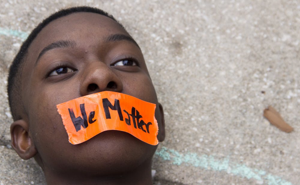 Sixteen-year-old Feliquan Charlemagne lies down Saturday during a die-in protest in front of Gainesville City Hall. Charlemagne is the co-founder of the Ocala chapter of March for Our Lives. Go to page 8 to read more.