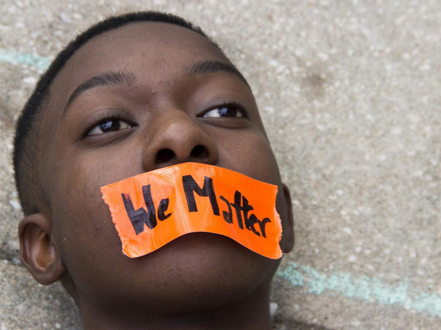 Sixteen-year-old Feliquan Charlemagne lies down Saturday during a die-in protest in front of Gainesville City Hall. Charlemagne is the co-founder of the Ocala chapter of March for Our Lives. Go to page 8 to read more.