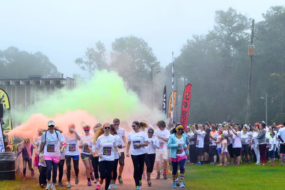 The second wave of runenrs take off from the starting line on Jan. 16, 2016, at the Alachua County Fairgrounds during the Color In Motion 5K run.