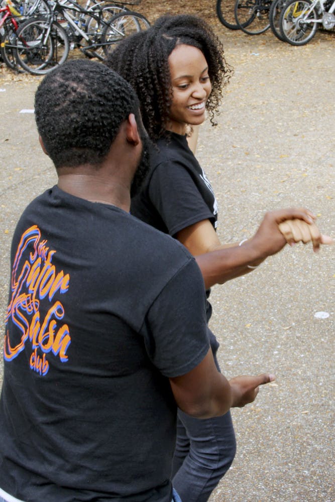 Naomi Ector, an 18-year-old biology freshman, and Christopher Duphren, a 21-year-old chemistry and french senior, dance with each other at Turlington Plaza Monday afternoon. Ector and Duphren are both a part of the Gator Salsa Club.