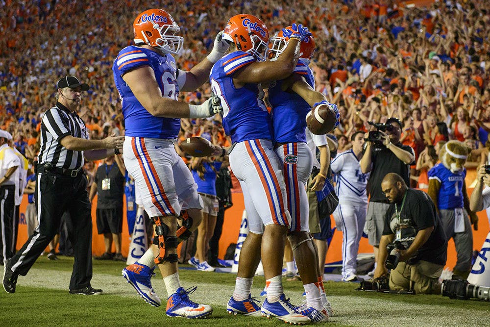 <p>Gators celebrate after Demarcus Robinson (11) OT TD during the match between the Florida Gators and the Kentucky Wildcats Staurday night in Ben Hill Griffin Stadium.</p>