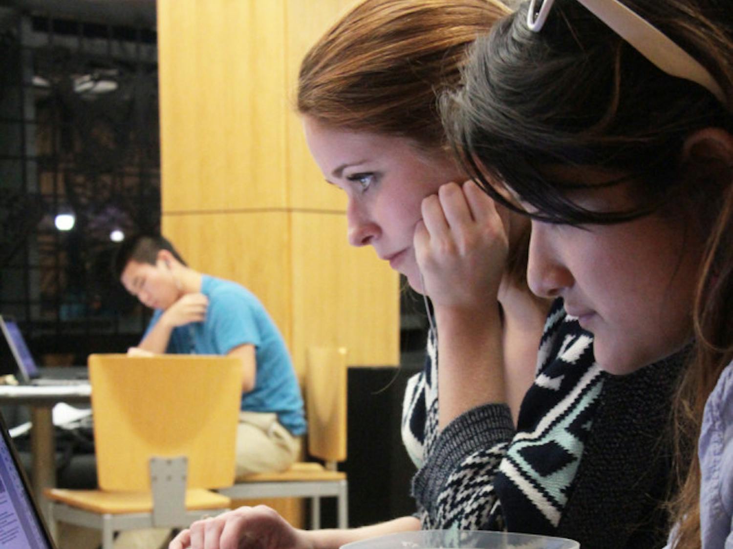 UF advertising juniors Katy Whitehurst, 20, and Ria Burgos, 20, study at Library West on Sunday night.