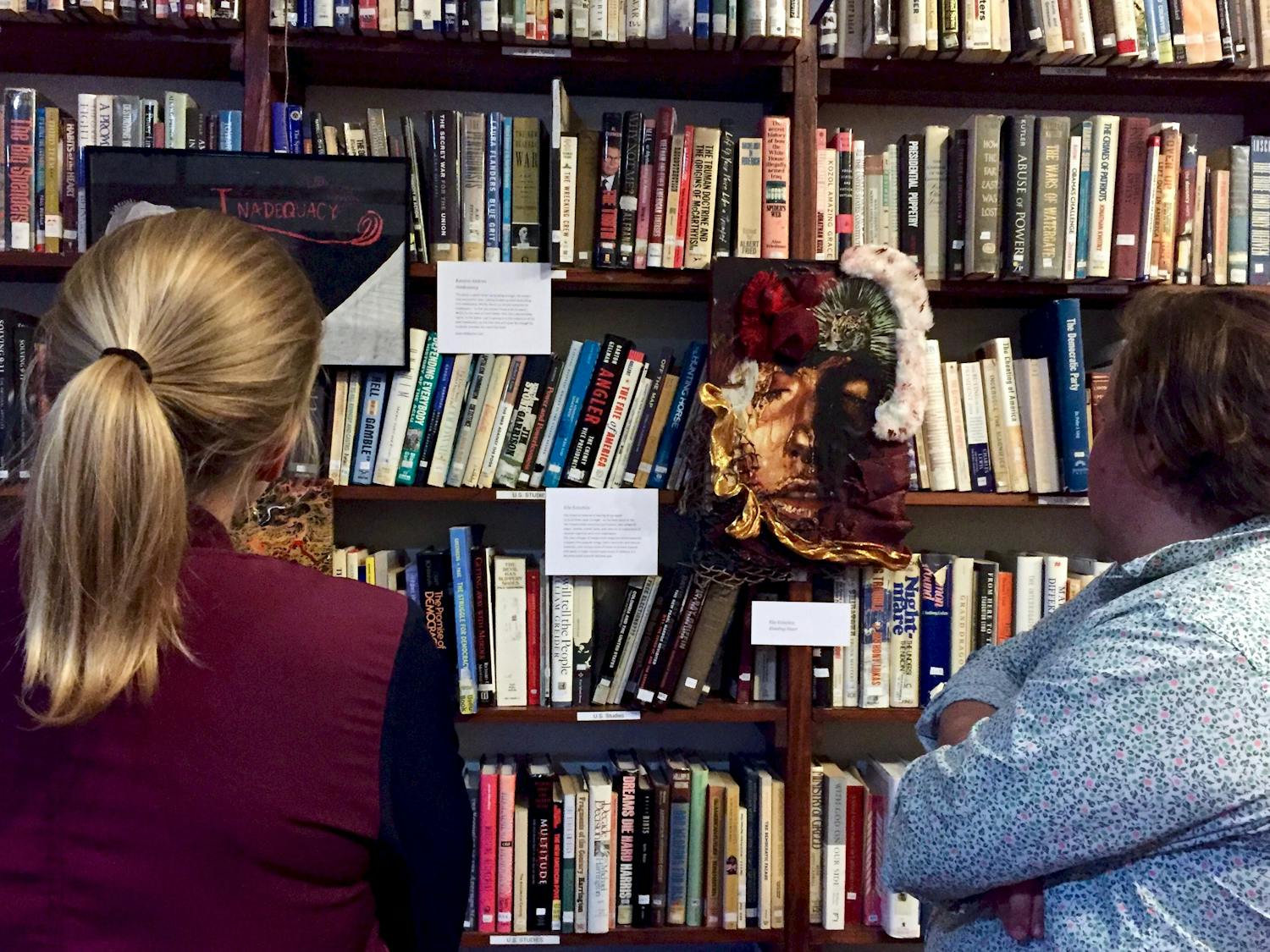 Eddie Valiant, 28, and Katie Zarada, 24, view artwork displayed at the Survivors of Violence Art Exhibit in the Civic Media Center, located at 433 S. Main St., on Friday night.