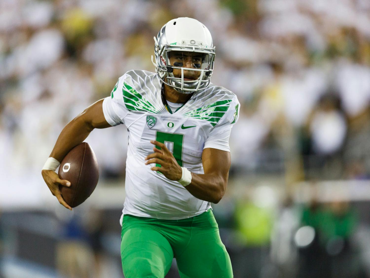 Oregon quarterback Marcus Mariota runs the football during the second quarter of an NCAA college football game against South Dakota in Eugene, Ore., Saturday, Aug. 30, 2014.