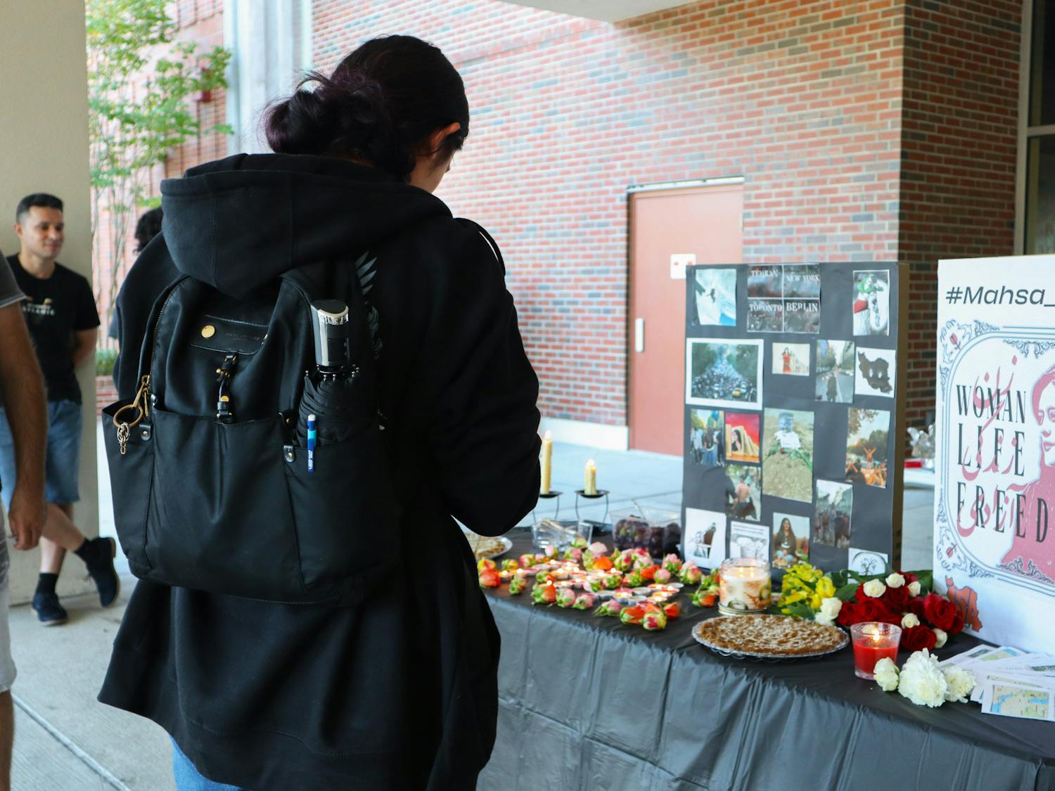 Marium Abdulhussein, 19, quietly recites Islamic funeral passages to the memorial of Mahsa Amini, Thursday, Sept. 22, 2022. Abdulhussein is a third-year student at UF.
