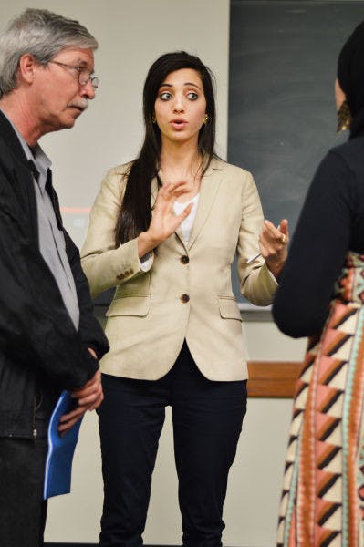 Mick Kelly, left, listens while Noor Elashi, center, discusses the itinerary with Sara Mohamed on Tuesday evening in Little Hall.