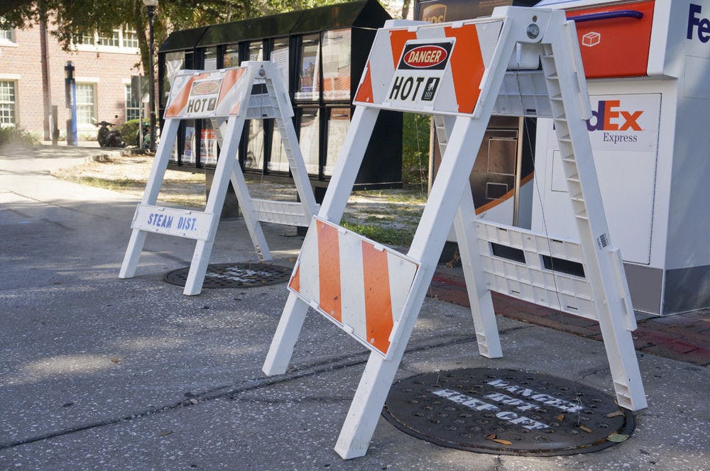 Safety barriers cover manholes emitting hot steam on the sidewalk along Stadium Road.&nbsp;