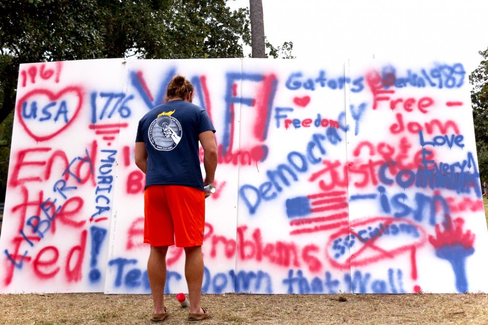 <p><span id="docs-internal-guid-47c33ff6-4c7b-f0b3-38fd-d503fbaec700"><span>Daniel Weldon, a 20-year-old UF political science sophomore and the president of Young Americans for Freedom, stands in front of a commemorative wall for the anniversary of the fall of the Berlin Wall on the Plaza of the Americas on Wednesday afternoon. Weldon said the event celebrated the triumph of freedom from socialism.</span></span></p>