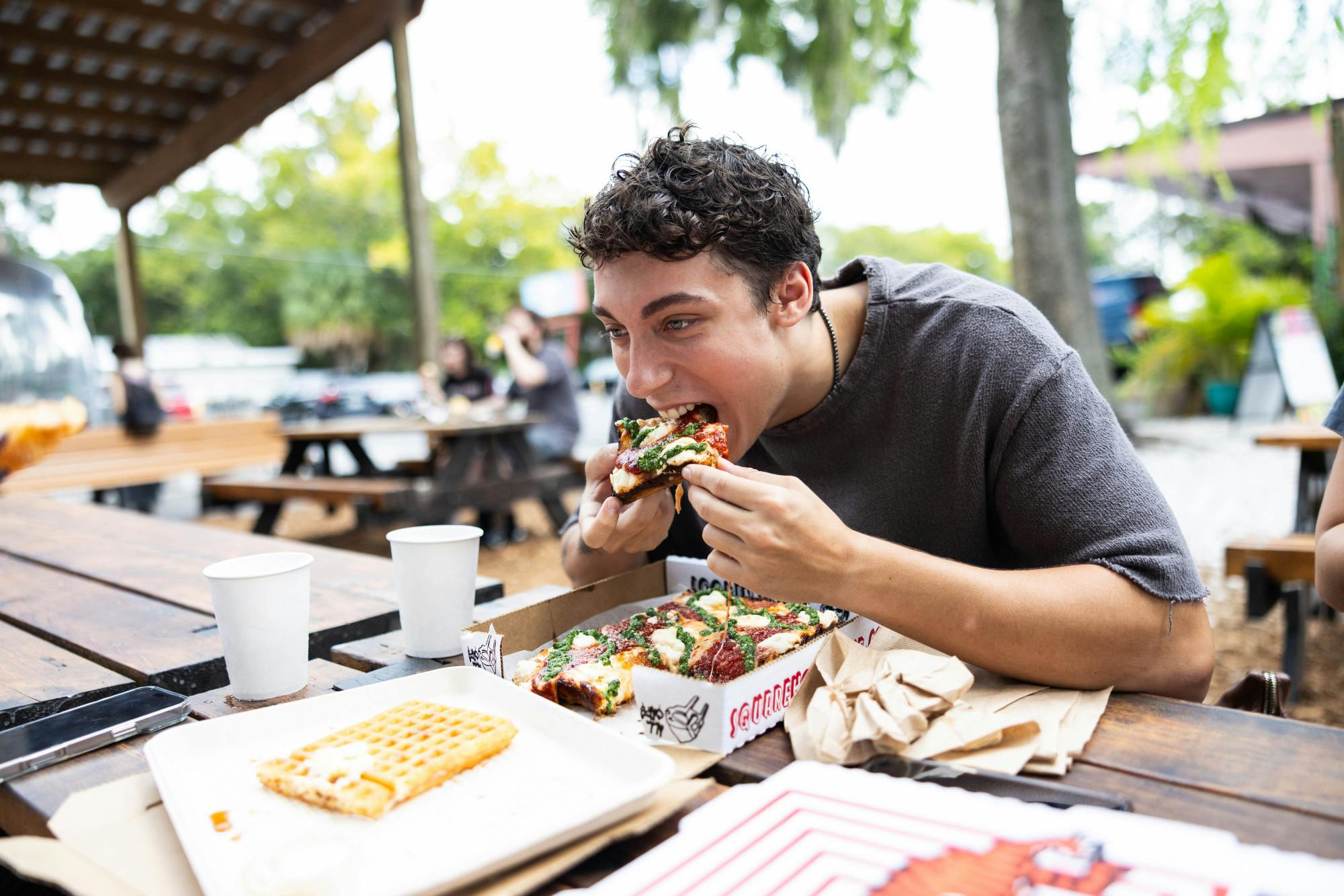 Aidan Ragan enjoys his order from SquareHouse Pizza on Saturday, Aug. 23, 2025.
