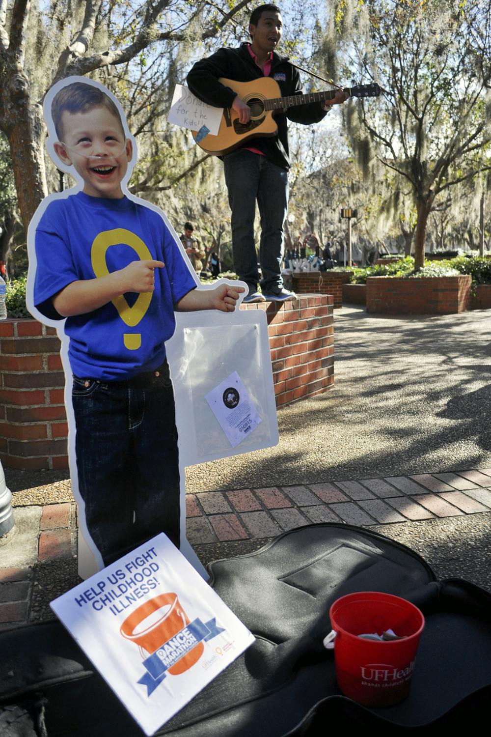 Christopher Dela Cruz, a 22-year-old UF APK senior, sings a cover version of the song “Rude” by Magic! A participant in Dance Marathon’s Transform Today initiative to raise $150,000 in one day, Dela Cruz was asking passers by to drop a donation in an open guitar case.