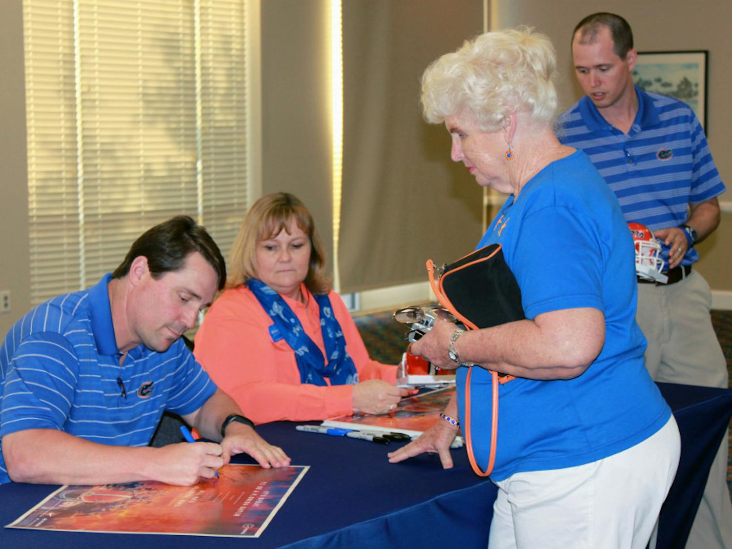 Will Muschamp signs autographs Tuesday afternoon after a press conference at Emerson Hall to discuss his plans for the upcoming season, which begins Aug. 30.