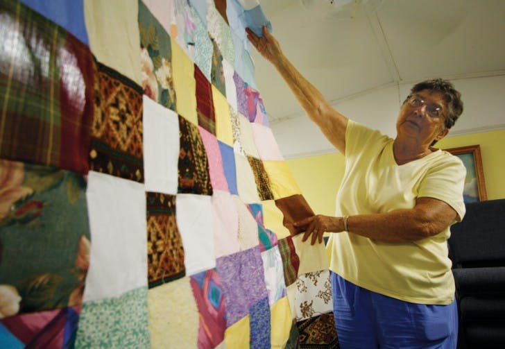 Wilma Smith, 78, displays a quilt stitched by members of Trinity Metropolitan Community Church of Gainesville. The group has been sewing all year with donated supplies, preparing to distribute the blankets to Gainesville’s homeless.