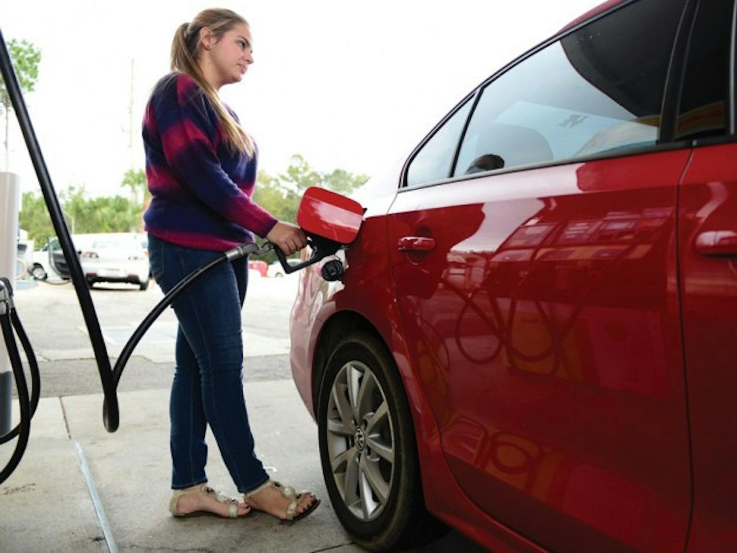 Chantelle Melendez, a 20-year-old psychology junior, pumps gas Tuesday at the Shell station at 3330 SW Archer Road. The average gas price in Florida is $3.43, said Gregg Laskoski, senior petroleum analyst for GasBuddy.com.