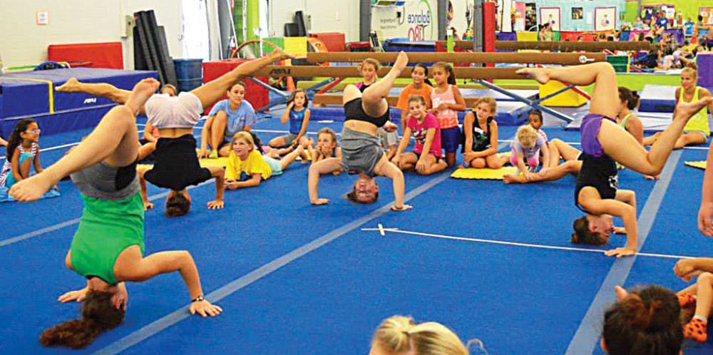 <p>Campers practice headstands at Balance180 Gym during the 2015 gymnastics summer camp.</p>