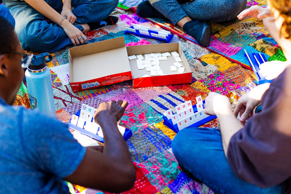 <p>UF Students play card games together at Plaza of the Americas on Thursday, Feb. 20, 2025.</p>