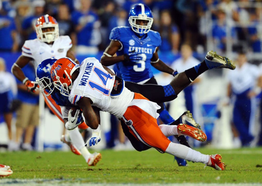 <p>Jaylen Watkins (14) tackles Kentucky wide receiver Alexander Montgomery during the Gators’ 24-7 victory against the Wildcats on Saturday at Commonwealth Stadium.</p>