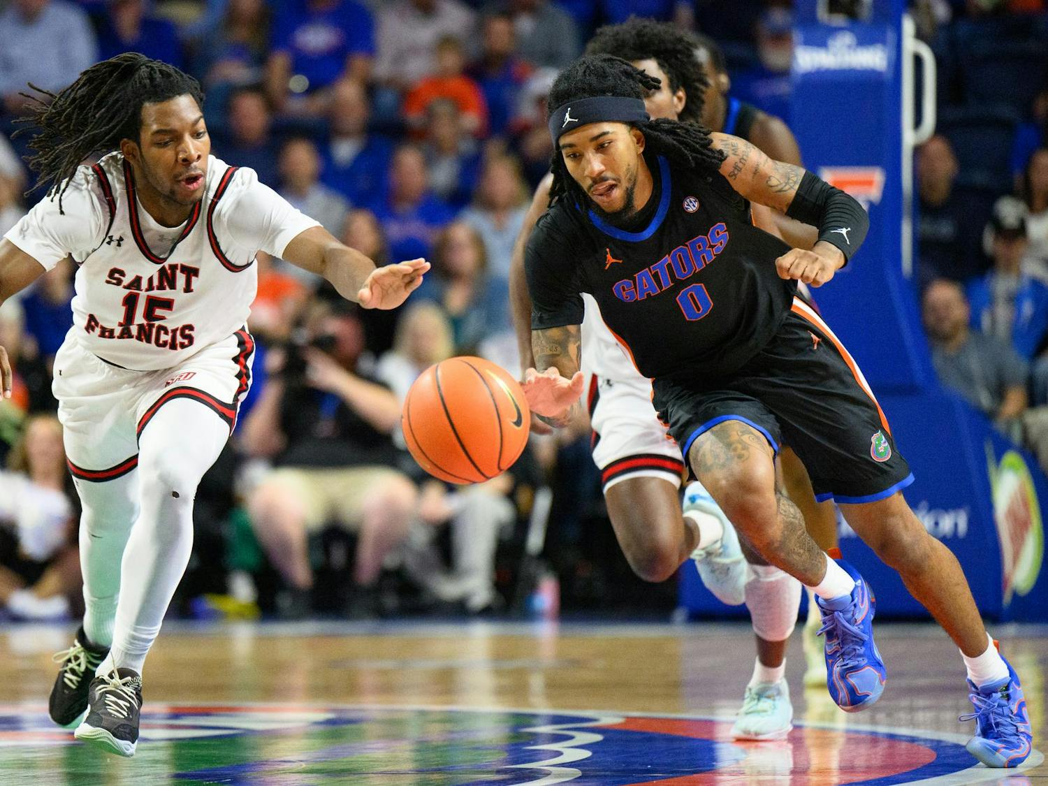 Florida guard Boogie Fland (0) chases a lost ball during the first half of an NCAA college basketball game against Saint Francis, Wednesday, Dec. 17, 2025, in Gainesville, Fla.