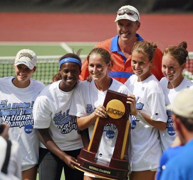 Members of Florida’s women’s tennis team pose with the 2012 NCAA Championship trophy in Athens, Ga., on Tuesday. UF defeated UCLA 4-0 to win its second consecutive national title.&nbsp;
