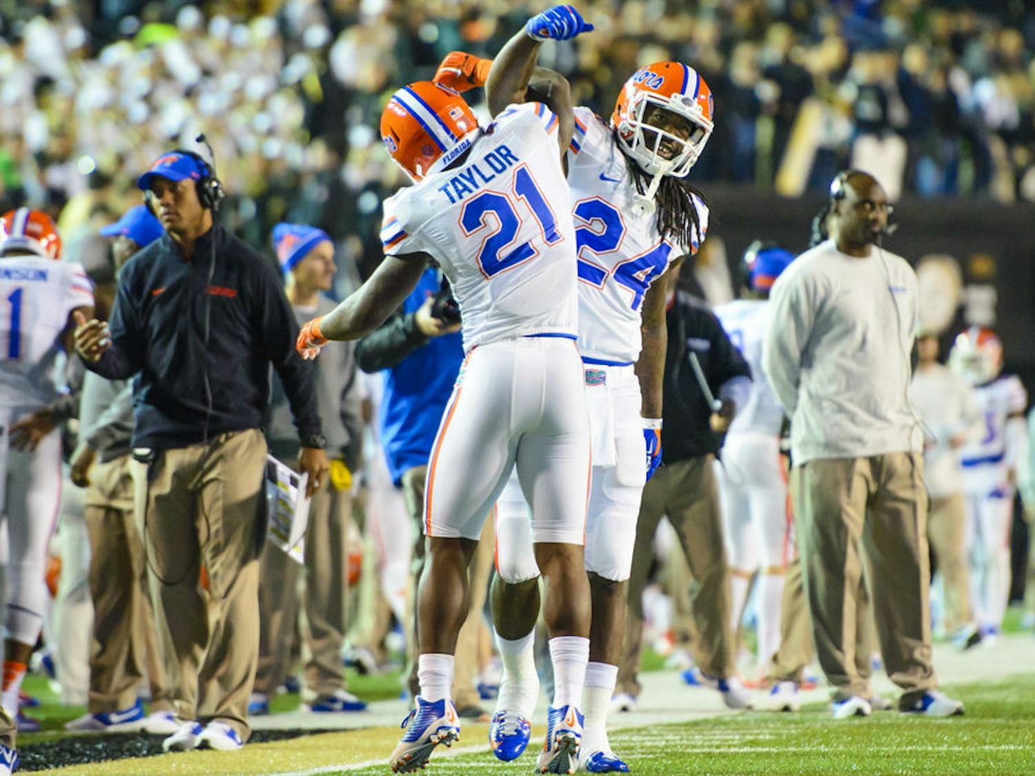 Florida running back Kelvin Taylor (21) celebrates with running back Matt Jones (24) following Taylor's touchdown in the first quarter of Gators' 34-10 win against Commodores on Saturday in Nashville, Tennessee.