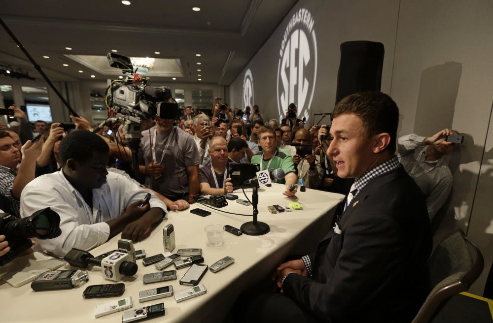 <p>Texas A&amp;M quarterback Johnny Manziel talks with reporters during the Southeastern Conference football Media Days in Hoover, Ala., on Wednesday.</p>