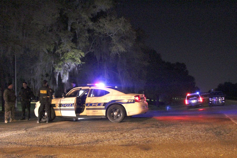 Law enforcement officers stand guard outside the entrance of Majestic Oaks Apartments early Monday morning. The officers stood outside for hours after GPD officers and Alachua County Sheriff’s deputies fatally shot a 16-year-old Gainesville resident who was carrying a replica rifle on Sunday night.