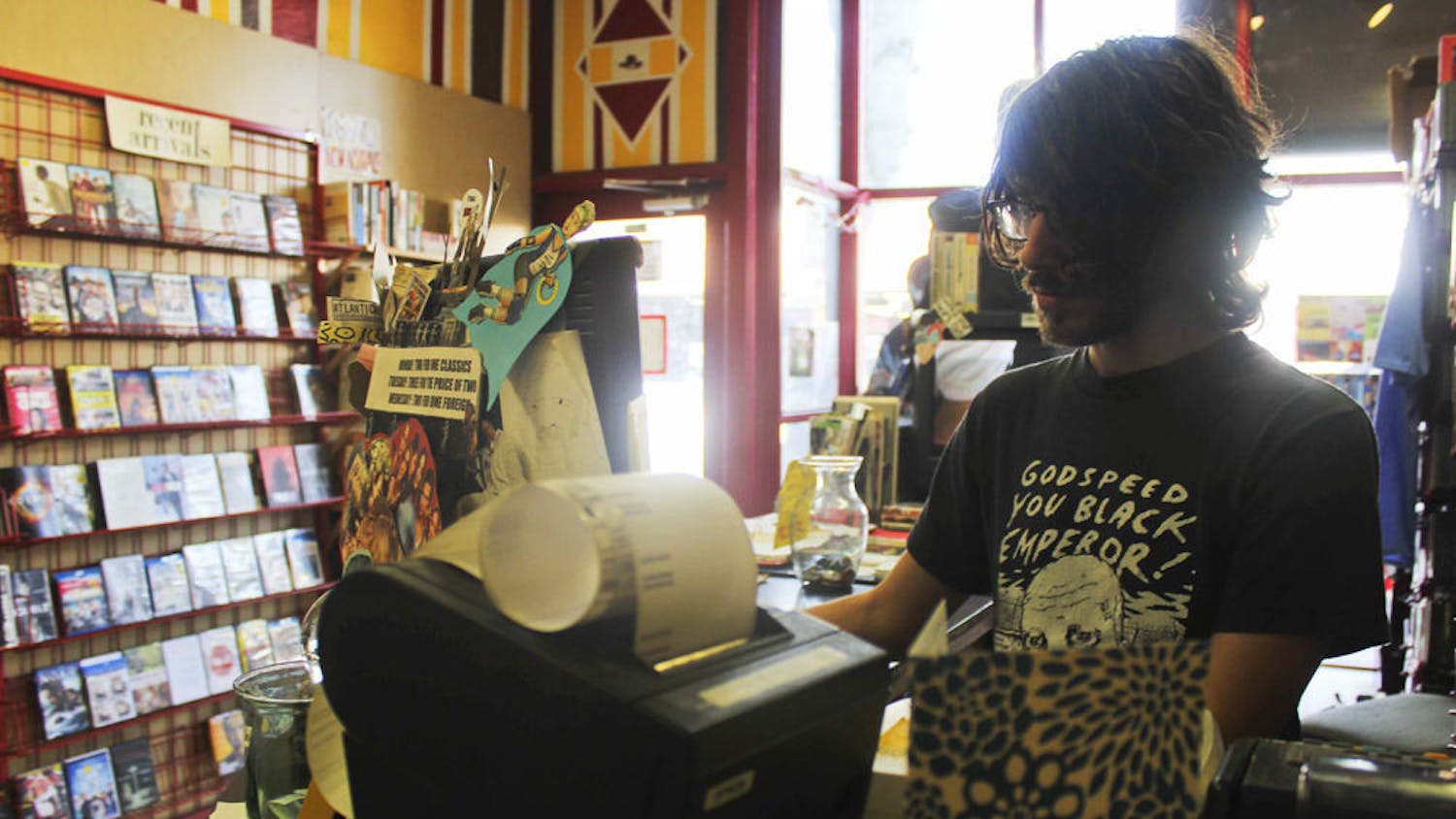 Ben Knazick, 24-year-old co-owner of Video Rodeo on West University Avenue, works at the store on Monday afternoon. The store will be moving to 10 E. University Ave.