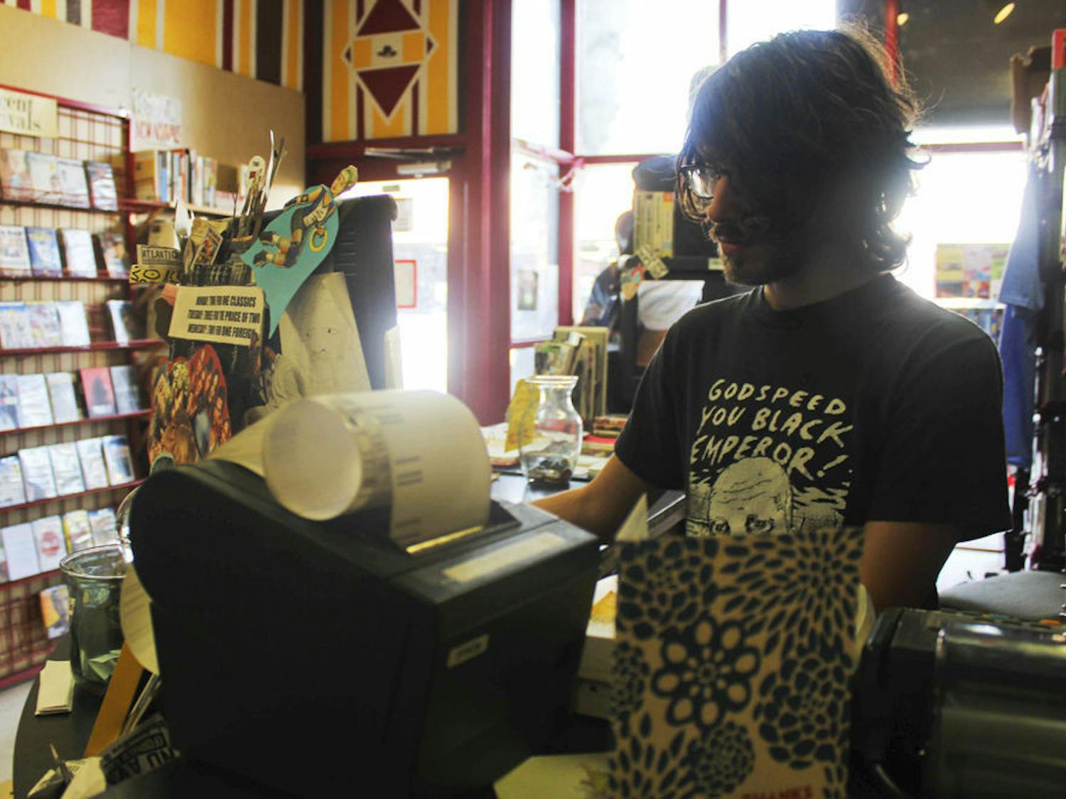 Ben Knazick, 24-year-old co-owner of Video Rodeo on West University Avenue, works at the store on Monday afternoon. The store will be moving to 10 E. University Ave.