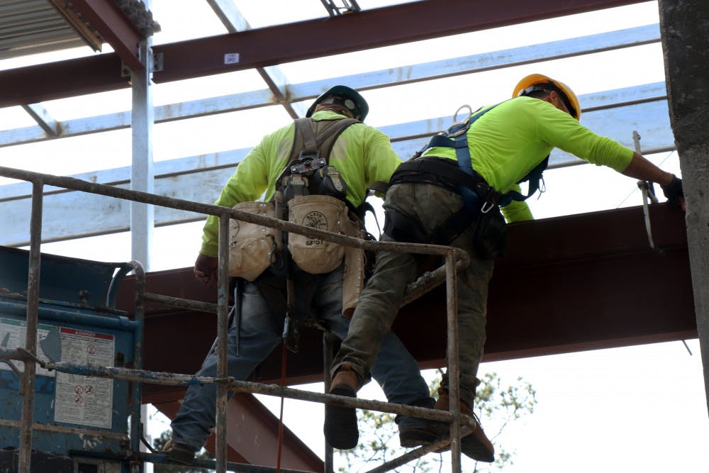 Crew members from Foresight Construction Group work Tuesday on the Institute of Black Culture on West University Avenue. A final structural steel beam will be placed on each of the buildings on Feb. 15. 