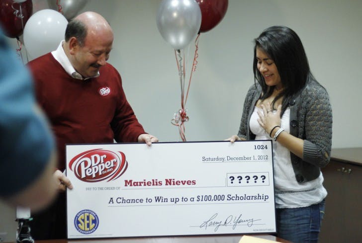 Chief marketing officer for Dr. Pepper Jim Trebilcock, left, presents Marielis Nieves, 18, of Saint Marys, Ga., with a check for $2,500 from her video entry in the Dr. Pepper Tuition Giveaway.