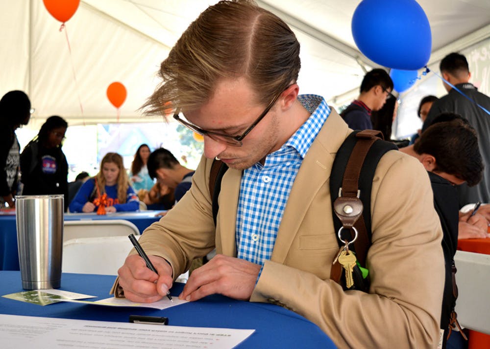 Jake Hughes, a UF chemical engineering junior, writes a letter at Grateful Gator Day. “It’s a cool idea,” he said. Hughes’ letter, addressed to Mr. and Mrs. Williams, was one of more than 2,000 that will be sent to donors.