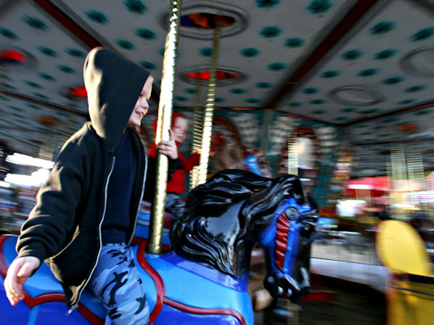 
A young boy rides the carousel at the Alachua County Fair in 2006. The fair, which was canceled in 2010 for the first time in 40 years due to financial problems, has paid its debts and will open its gates once more in October.