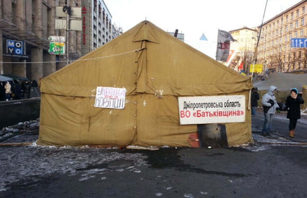 <p class="p1"><span class="s1">A tent sits in a street displaying signs reading “Ukraine Without Corruption.” The Ukrainian people are protesting after the local government refused to join the European Union. Three people have died, and the prime minister, Mykola Azarov, resigned on Tuesday.</span></p>