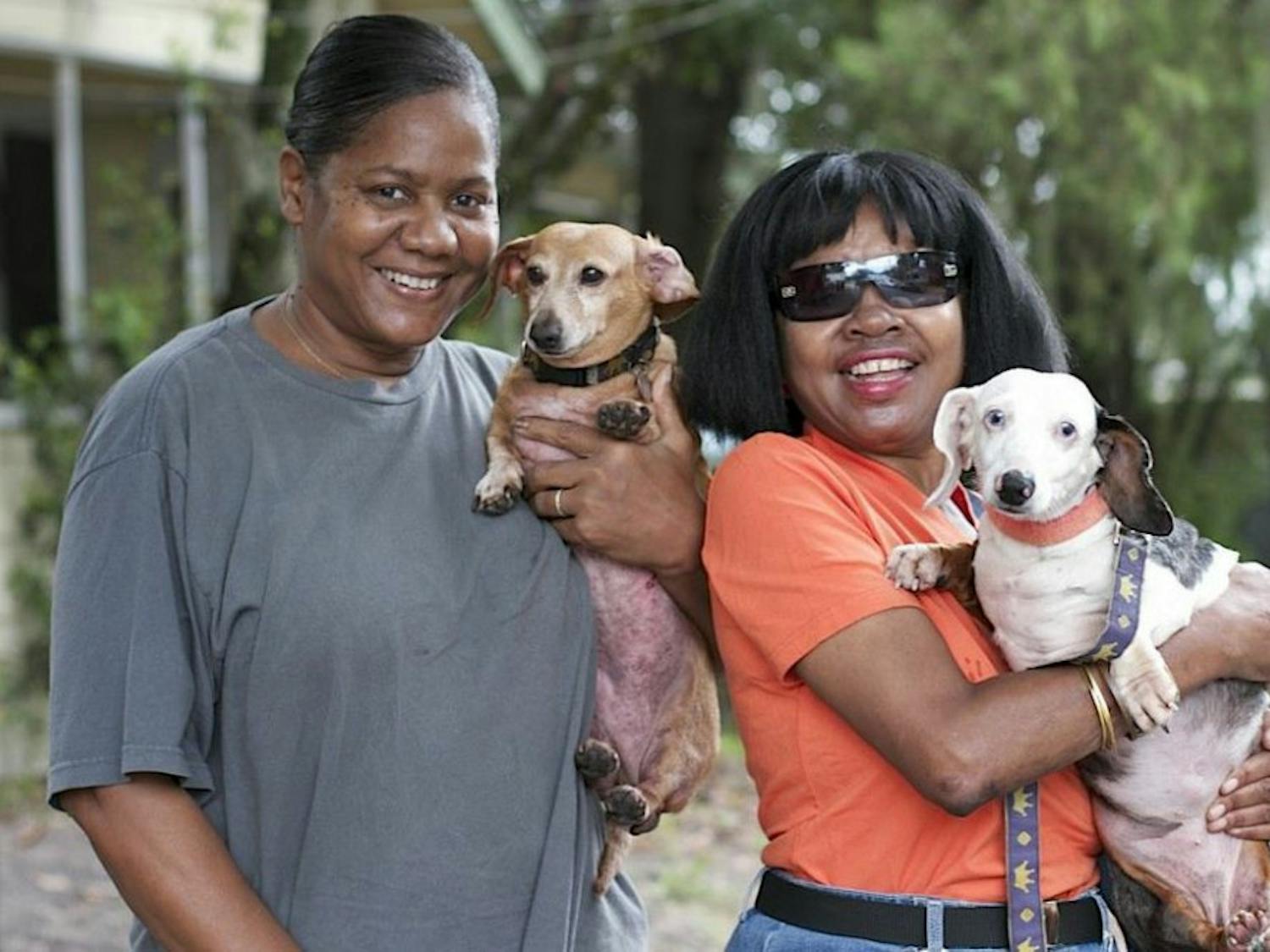 Vera Mathews (left) holds Nate, and Yvette Mathews holds Bella as they pose for a photo at St. Francis Pet Care.