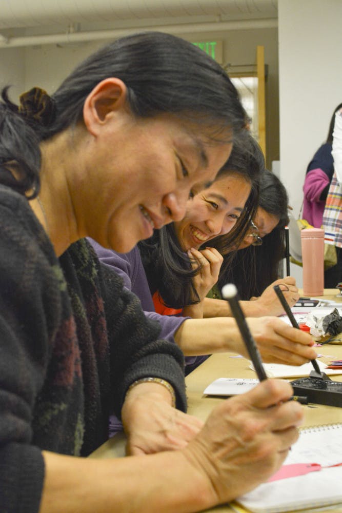 Wenhsing Wu, a lecturer in UF’s Department of Electrical and Computer Engineering, and Yii-Shyuan Chen, a UF genotyping lab technician, write Chinese calligraphy at the Samuel P. Harn Museum of Art.