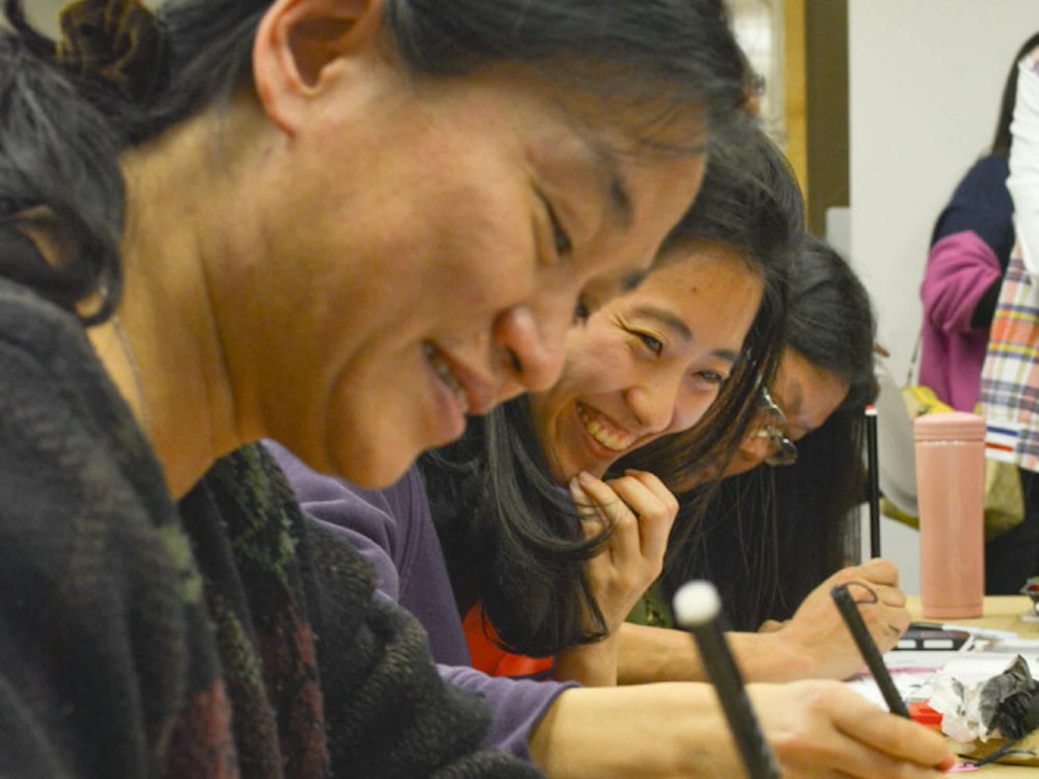 Wenhsing Wu, a lecturer in UF’s Department of Electrical and Computer Engineering, and Yii-Shyuan Chen, a UF genotyping lab technician, write Chinese calligraphy at the Samuel P. Harn Museum of Art.