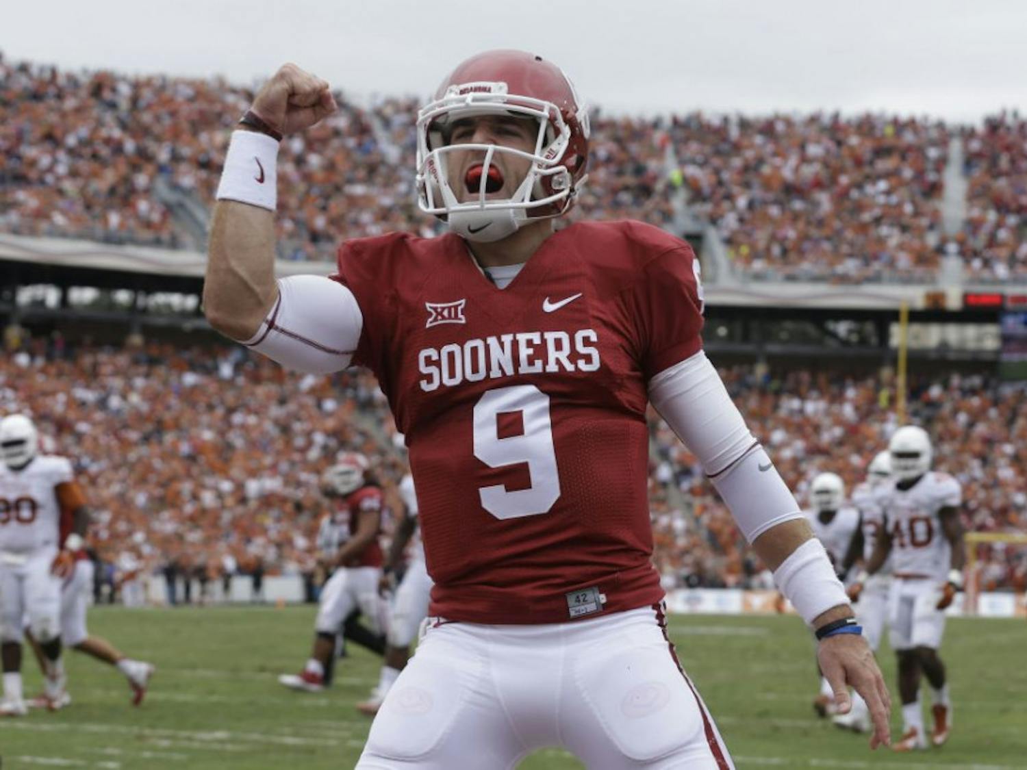 Oklahoma quarterback Trevor Knight (9) celebrates a touchdown by teammate Samaje Perine during the second half of an NCAA college football game against Texas at the Cotton Bowl, Saturday, Oct. 11, 2014, in Dallas. 