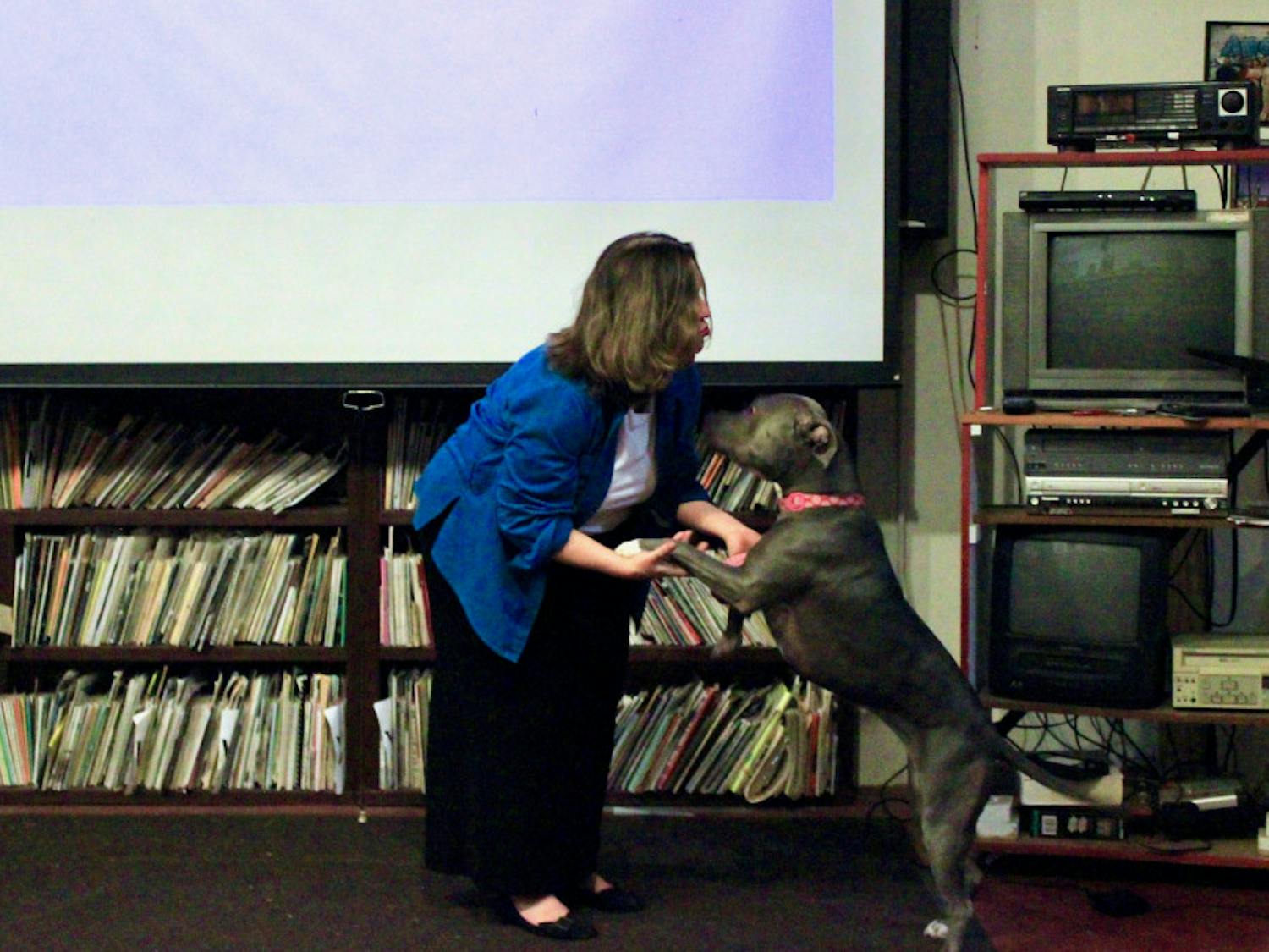 Lori, a support dog, greets Marcy LaHart, a Micanopy-based animal law lawyer, during her speech at the Civic Media Center in downtown Gainesville Tuesday evening.