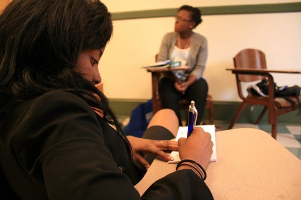 <p>Melissa Clarke, an 18-year-old health science freshman, writes down websites that will help her prepare for an interview at the 10th Annual Black Student Leadership Conference on Saturday afternoon.</p>