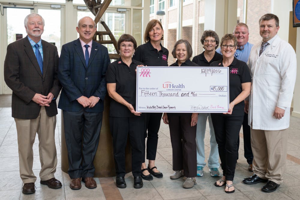 Survivors for Research presenting their yearly donation to Dr. Jonothan Licht, Director of the Cancer Center, and a group of breast cancer researchers. From Left: Dr. Wingard, Dr. Licht, Barb Thomas, Tammy Bernard, Dr. Beverly Roberts, Cheri Knecht, Terry Weber, Brian Sevier, Dr. Coy Heldermon.  
