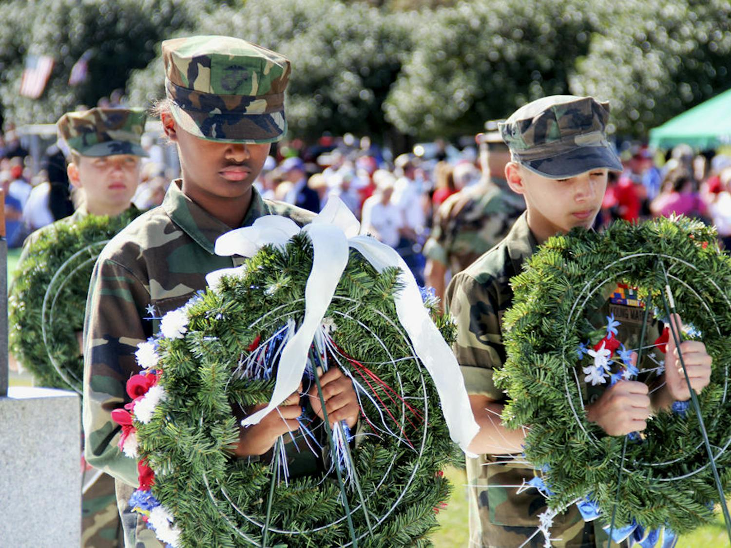 Nine-year-olds Recruit Jacqueline Gaston and Pvt. Dylan Russell, along with fellow cadets from the Milton Lewis Young Marines, return wreaths back to their rightful places.