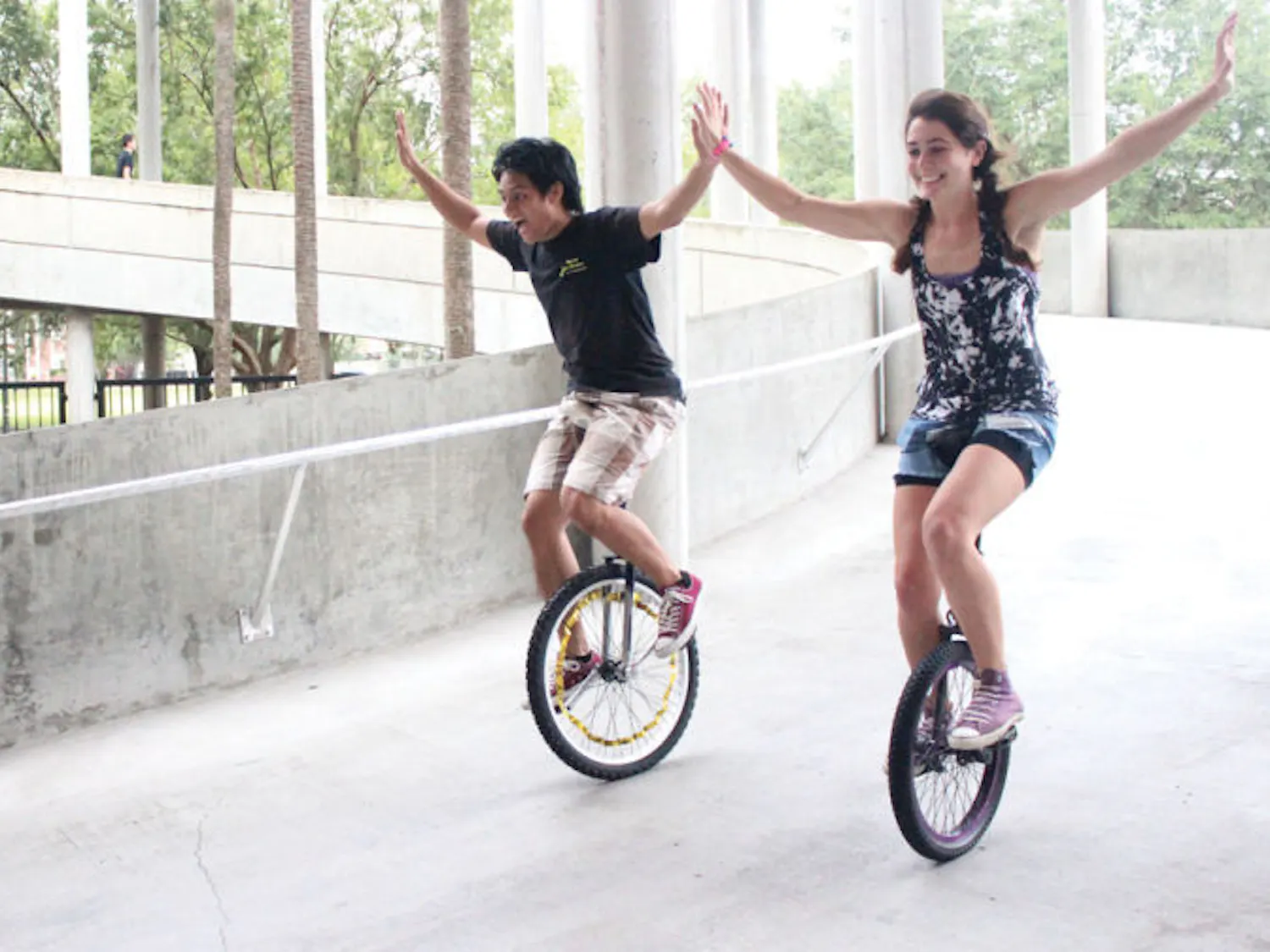 UF alumnus PJ Arroyo, 24, rides a unicycle down a slope with Florida State University senior Maria Vaccaro, 21, at the Gainesville Unicycle Fest on Saturday. The festival included events such as races, hockey, limbo and football, all balanced on one wheel.