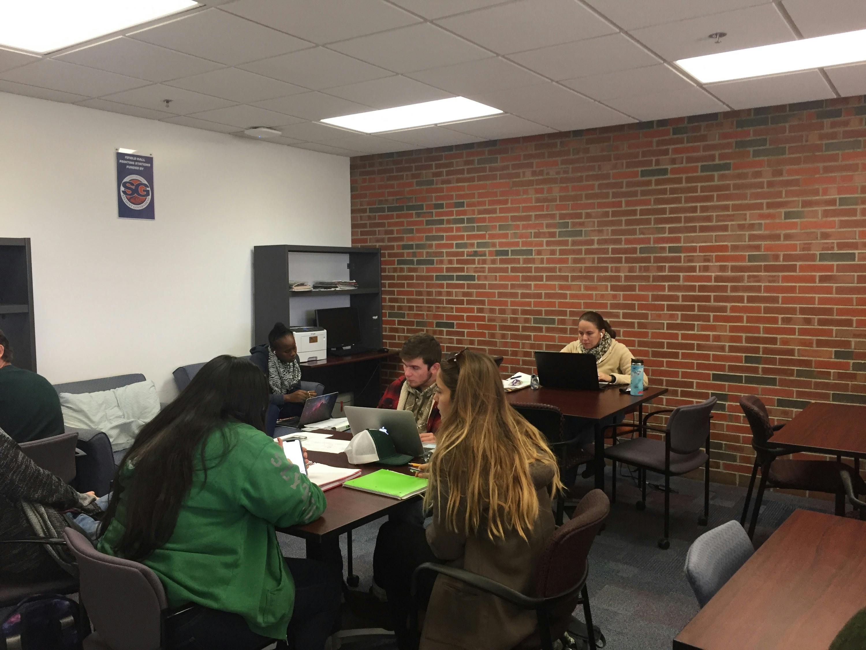 A new printer from Student Government sits tucked behind desks at Fifield Hall. The printer will allow students to use the 250 prints they receive from UF Student Government each semester. 