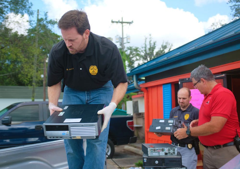<p>Detective Rob Concannon, Detective Matt Goeckel and Sgt. Greg Armagost load computers marked for evidence in a truck Tuesday. Gainesville Police raided Gators Hot Spot Sweepstakes, an Internet cafe, after a judge issued a search warrant.</p>