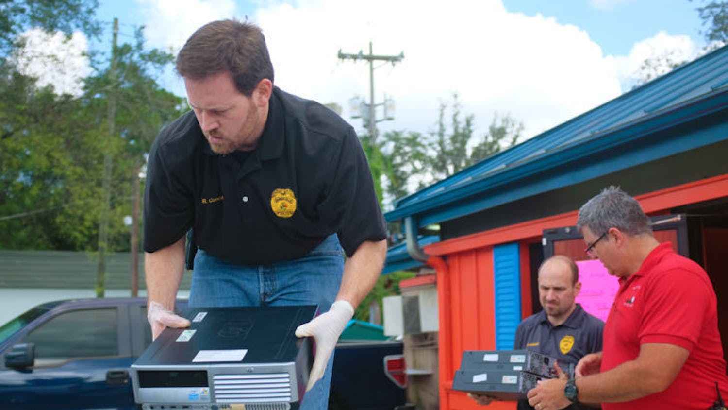 Detective Rob Concannon, Detective Matt Goeckel and Sgt. Greg Armagost load computers marked for evidence in a truck Tuesday. Gainesville Police raided Gators Hot Spot Sweepstakes, an Internet cafe, after a judge issued a search warrant.