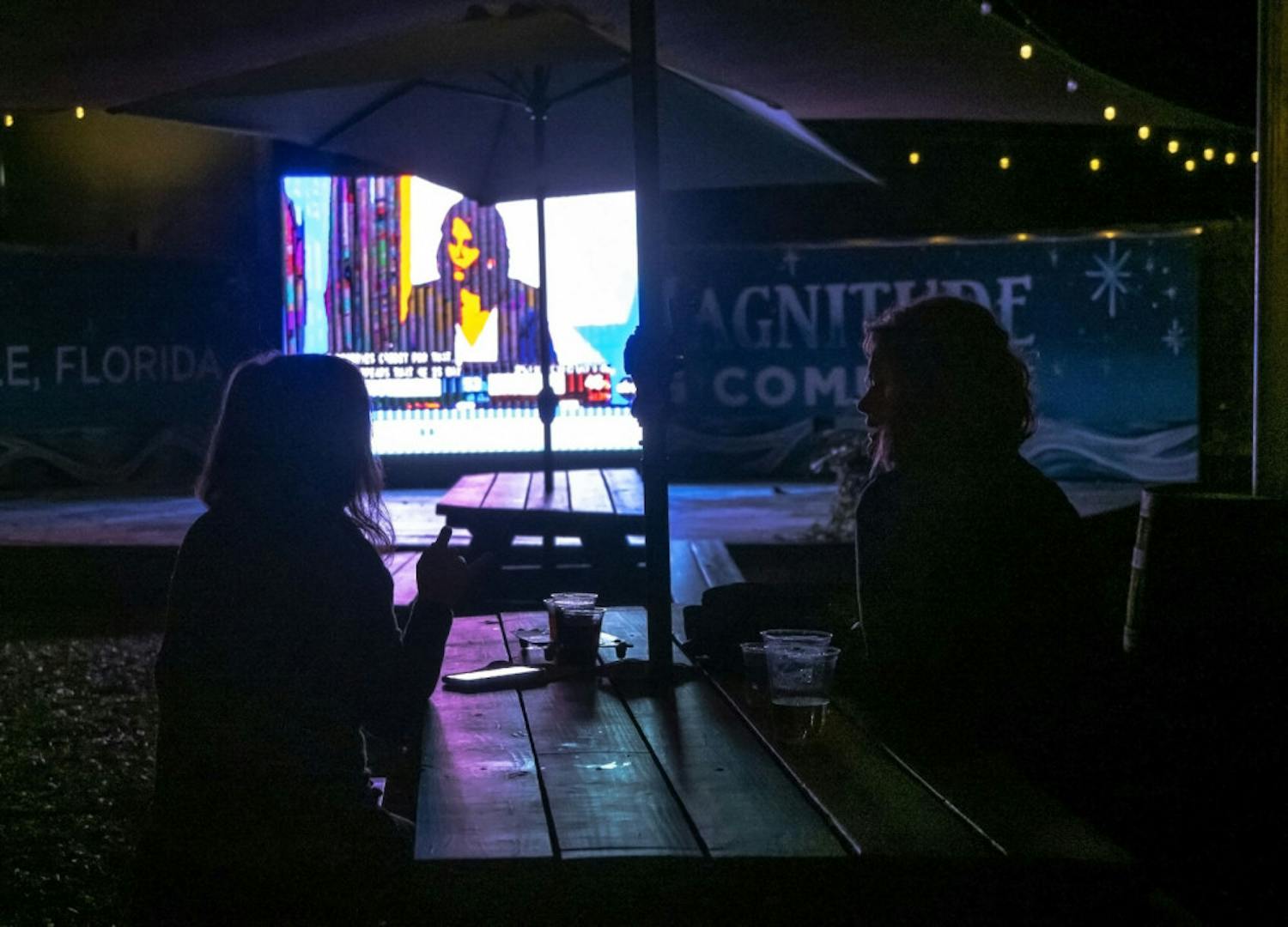 Two women watch the presidential election results at First Magnitude Brewery, located in Gainesville, Fla., on Tuesday, Nov. 3, 2020.