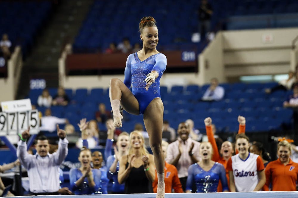Florida's Kytra Hunter draws support from her team, rear, as she runs through her floor exercise routine during the NCAA women's Gymnastics Championships Friday, April 17, 2015, in Fort Worth, Texas.
