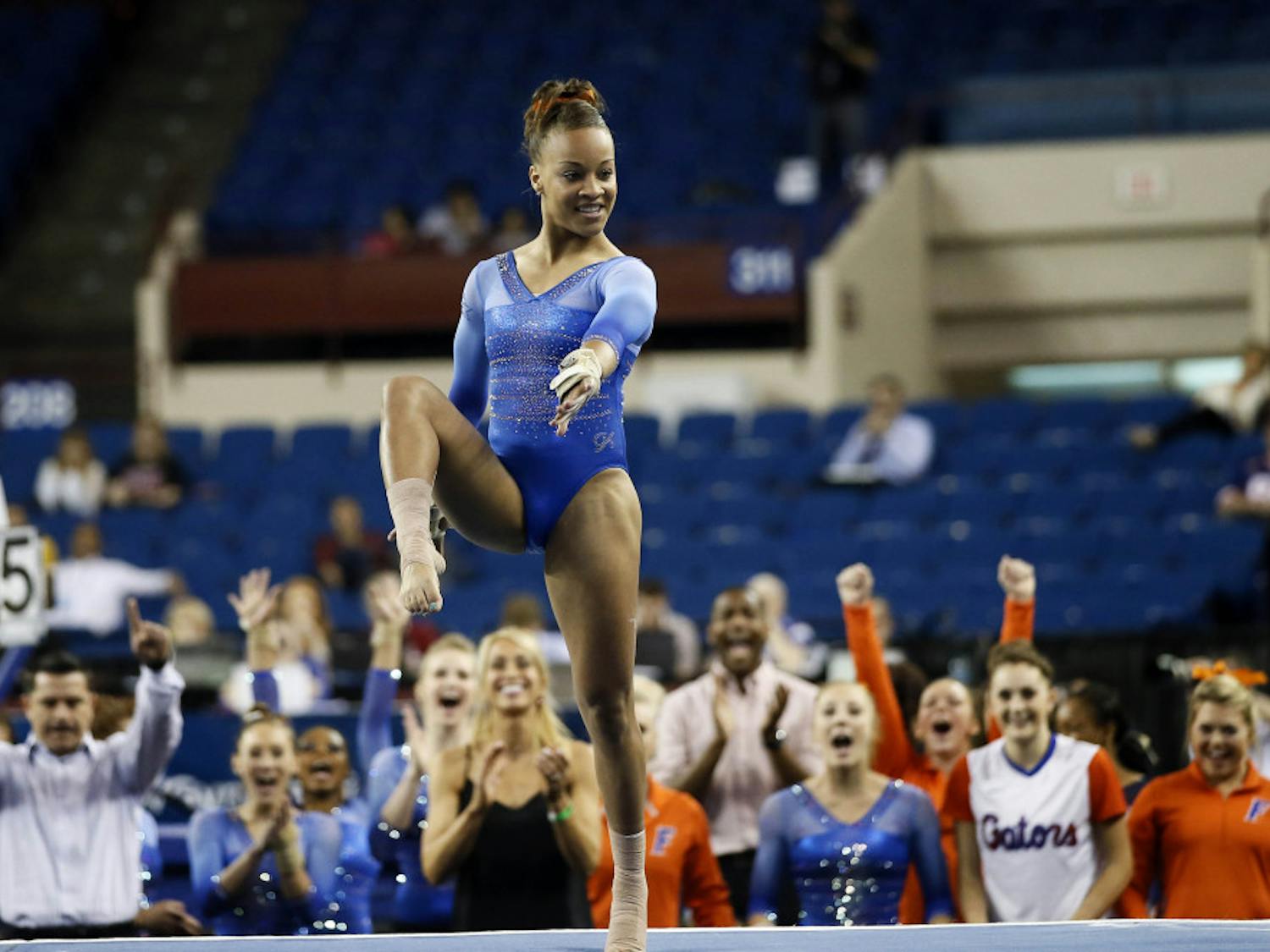 Florida's Kytra Hunter draws support from her team, rear, as she runs through her floor exercise routine during the NCAA women's Gymnastics Championships Friday, April 17, 2015, in Fort Worth, Texas.