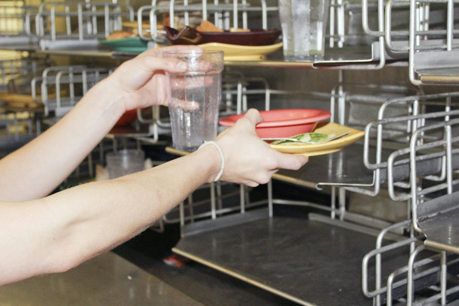 Pictured is a student placing waste on the conveyer belt in the Broward Dining Center.