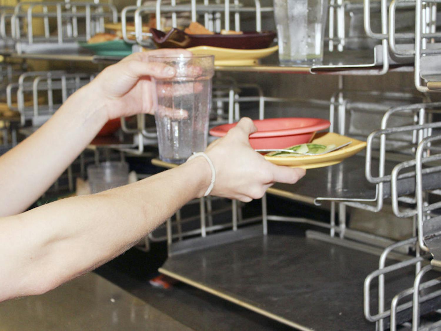 Pictured is a student placing waste on the conveyer belt in the Broward Dining Center.